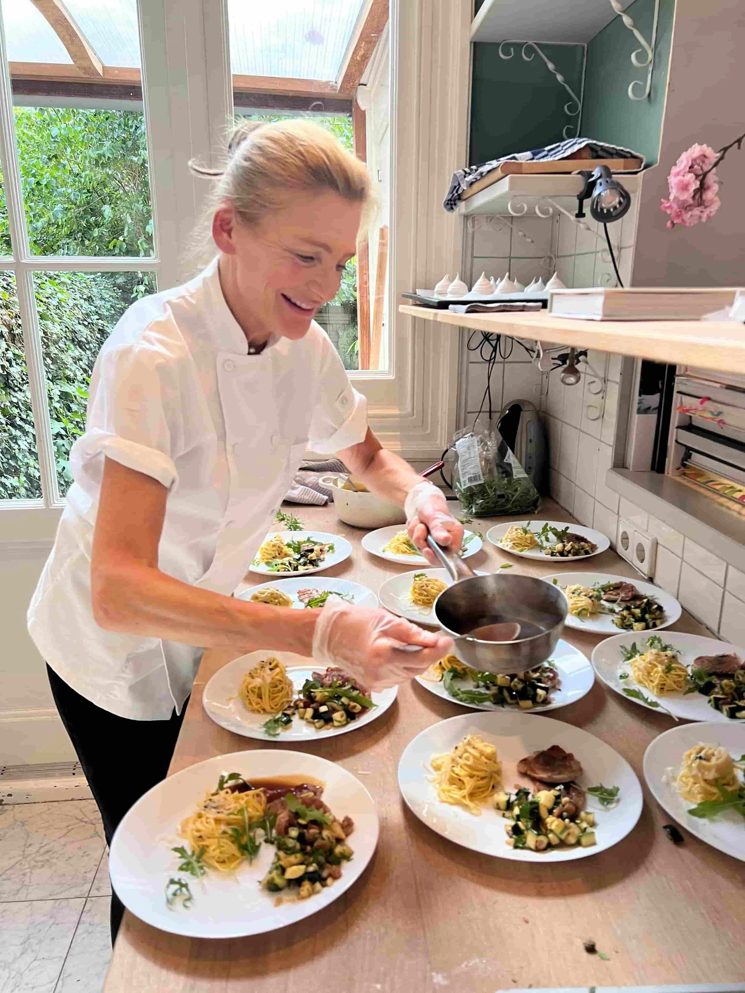 Chef Adrienne cooking in her Amsterdam home kitchen, enjoying the process of preparing seasonal meals.