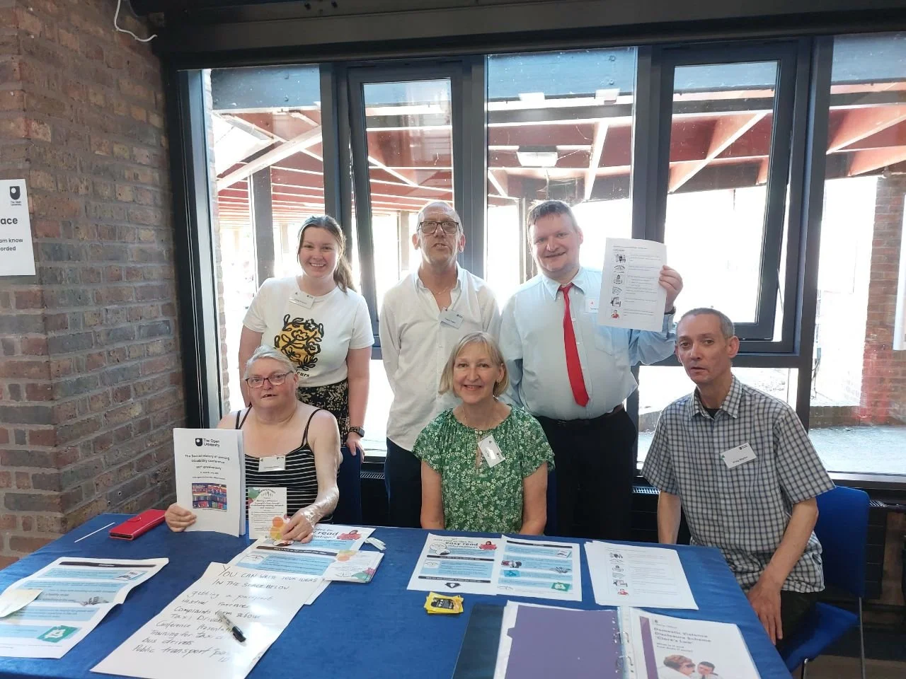 The building bridges team sitting behind a table at the Open University in Milton Keynes