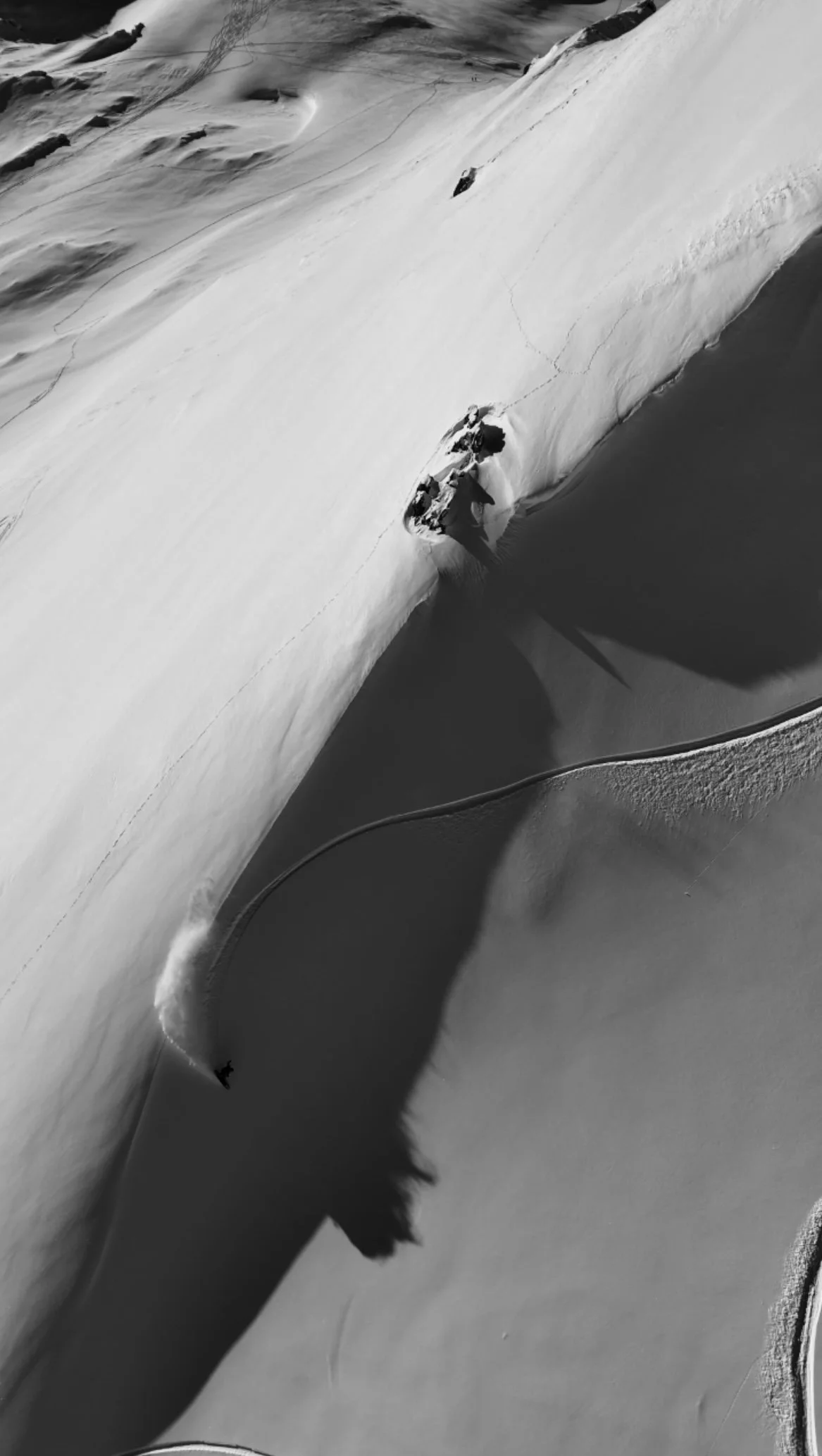 A person snowboarding down a steep snow-covered mountain slope in Tignes and Val D'isere.