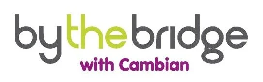 Text logo that reads 'by the bridge' with 'with Cambian' underneath.
