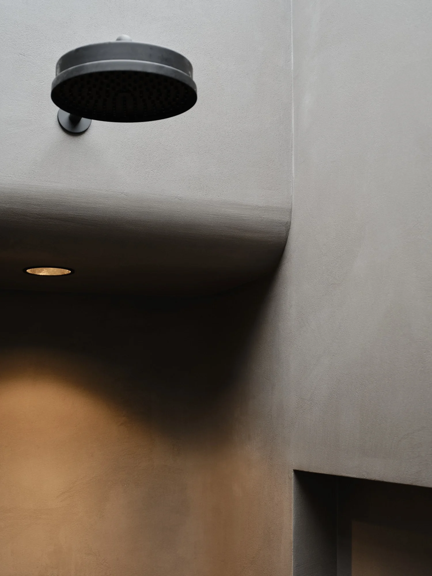 Rounded corners in the master shower, microcement finish to walls and floors