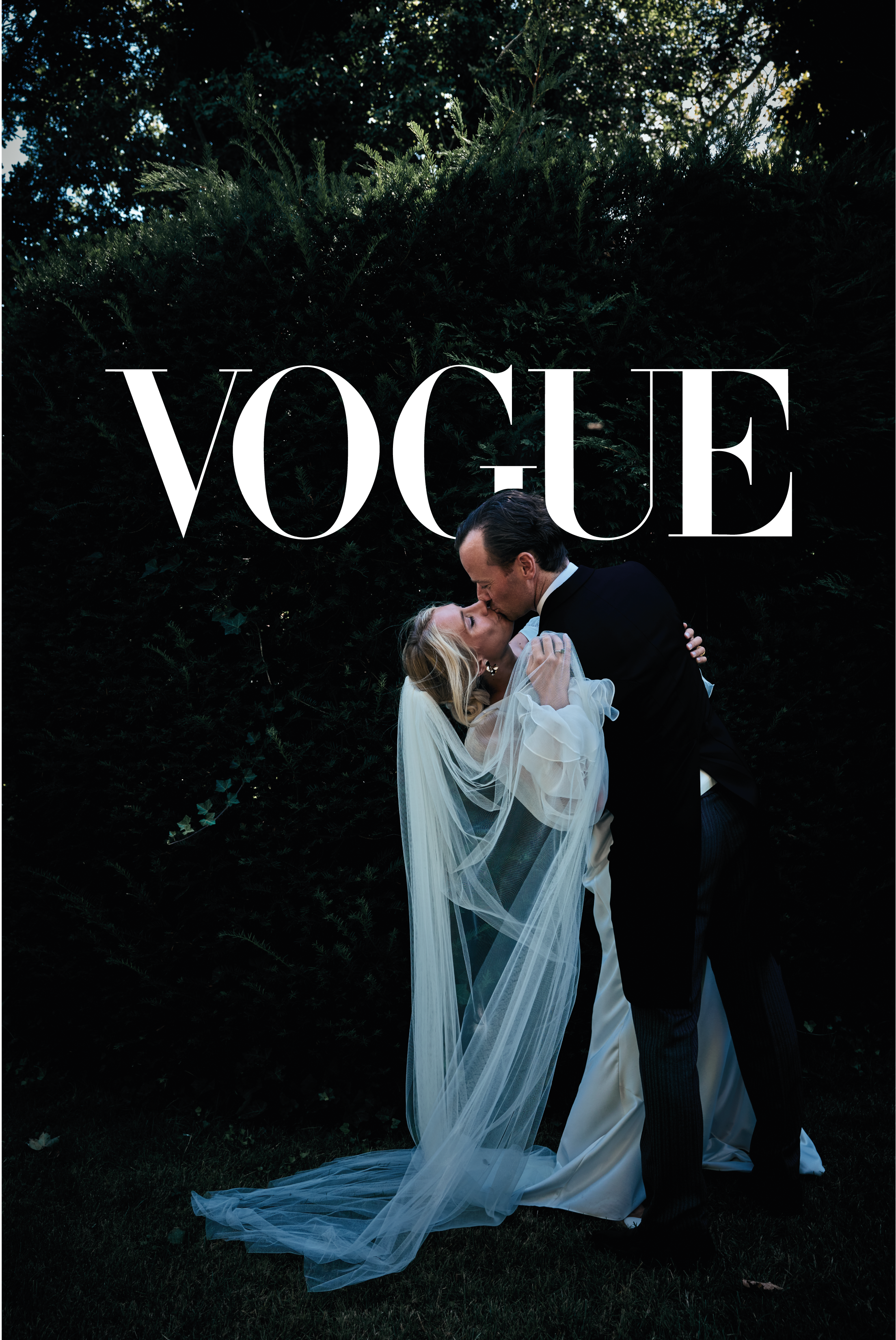 Een bruid en bruidegom kussen elkaar buiten, met een dichtbegroeide achtergrond en de tekst 'VOGUE' boven hen.