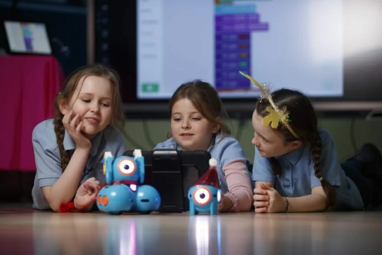 Three girls learning to code with Dash and Dot robots