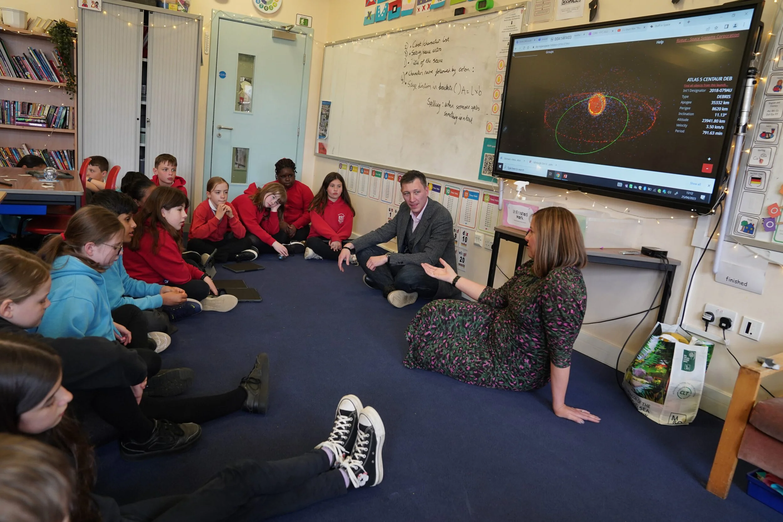 Group of learners hearing about how tech is used in space from two staff from CGI