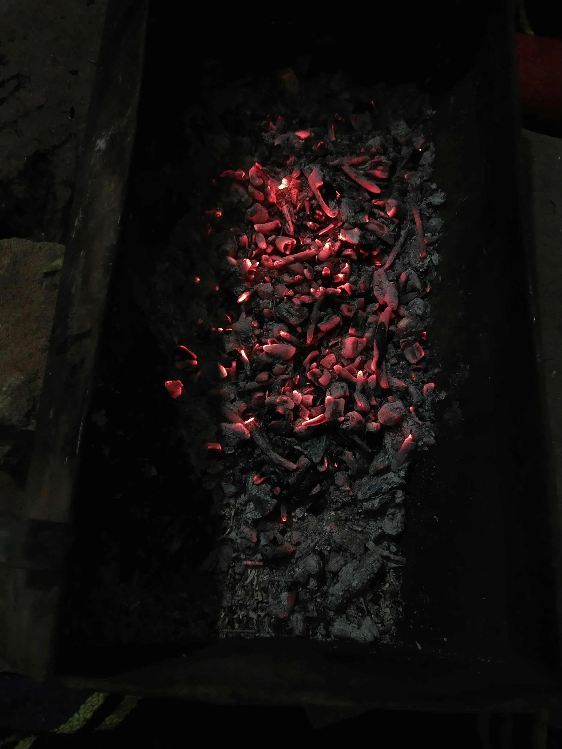 Hot, glowing charcoal in a fire pit.