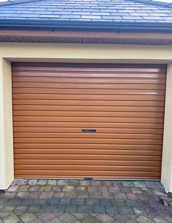 Brown roll-up garage door on a house with a paved driveway
