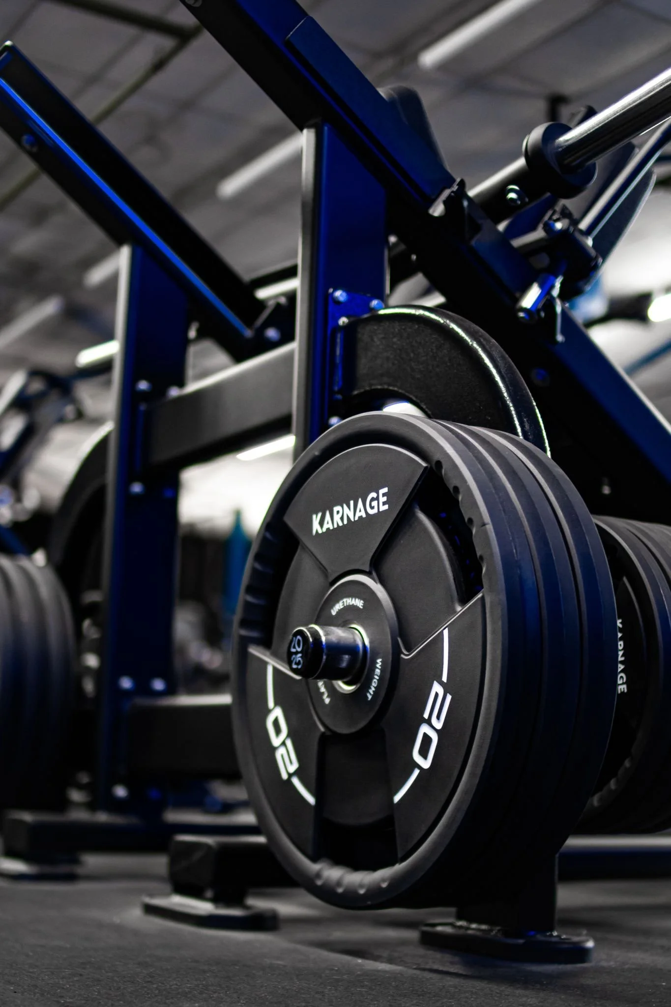 Close-up view of a rowing machine with a black and silver flywheel in a gym setting.