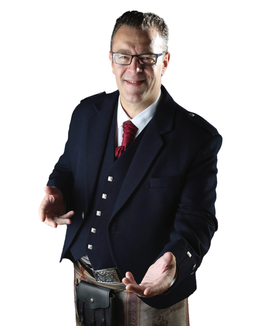 A man wearing a dark suit with a white shirt, red tie, and glasses, smiling with arms outstretched and hands open.