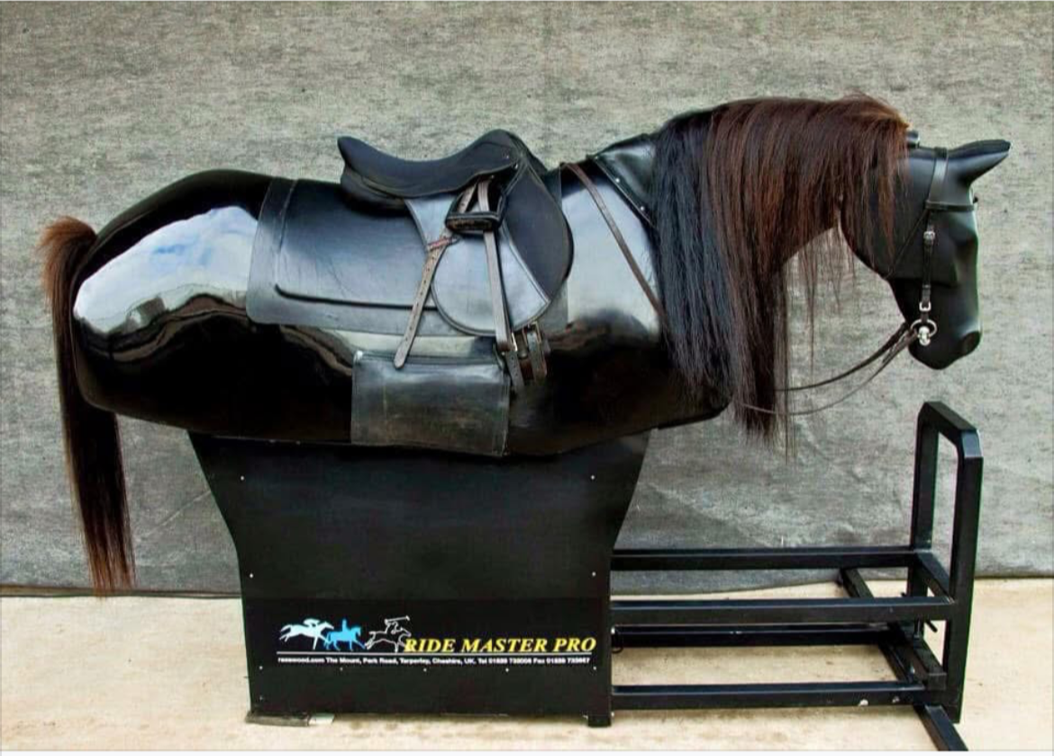 A black mechanical horse with a brown mane and tail on a black platform, equipped with a saddle and bridle