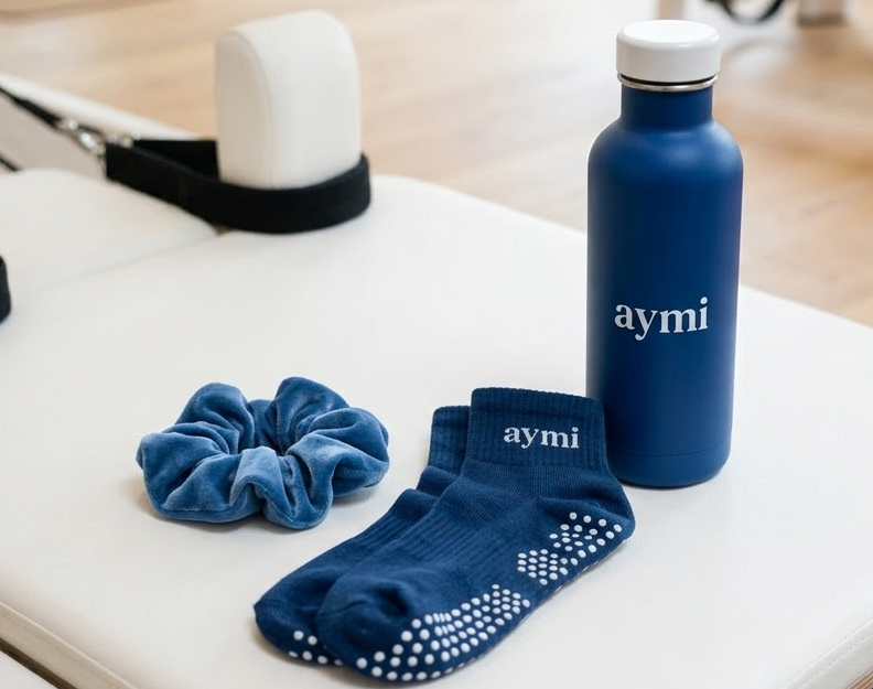 une bouteille bleue, une paire de chaussettes bleues et un chouchou en tissu bleue sur une surface blanche