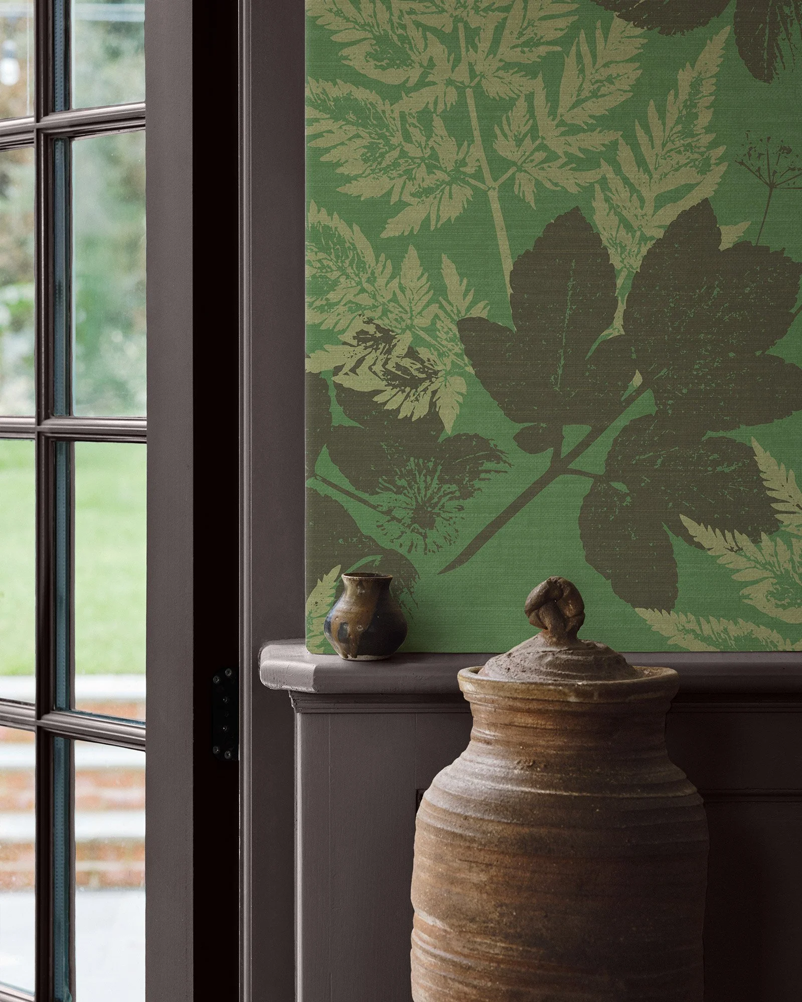 Silhouette of various leaves and a flower on a textured brown background.