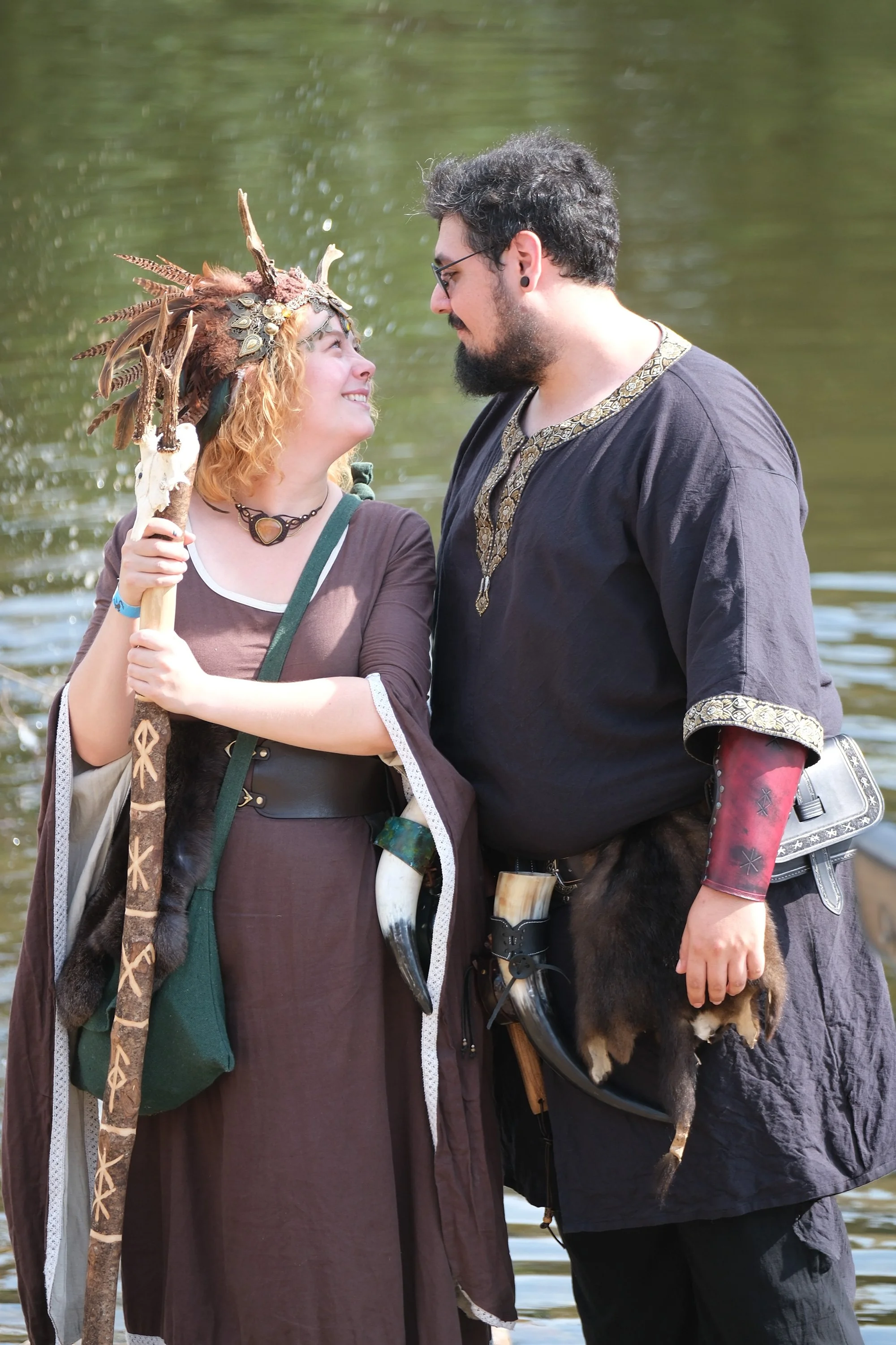 Deux personnes habillées comme des personnages mythologiques ou médiévaux, se regardant avec un fond d'eau.