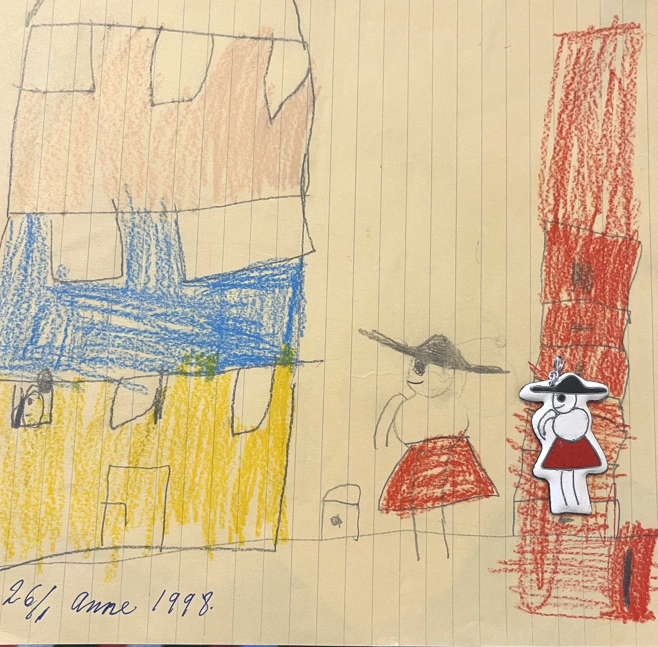 Børnetegning af hus og en person med hat - og et emaljevedhæng, som forestiller personen på tegningen.