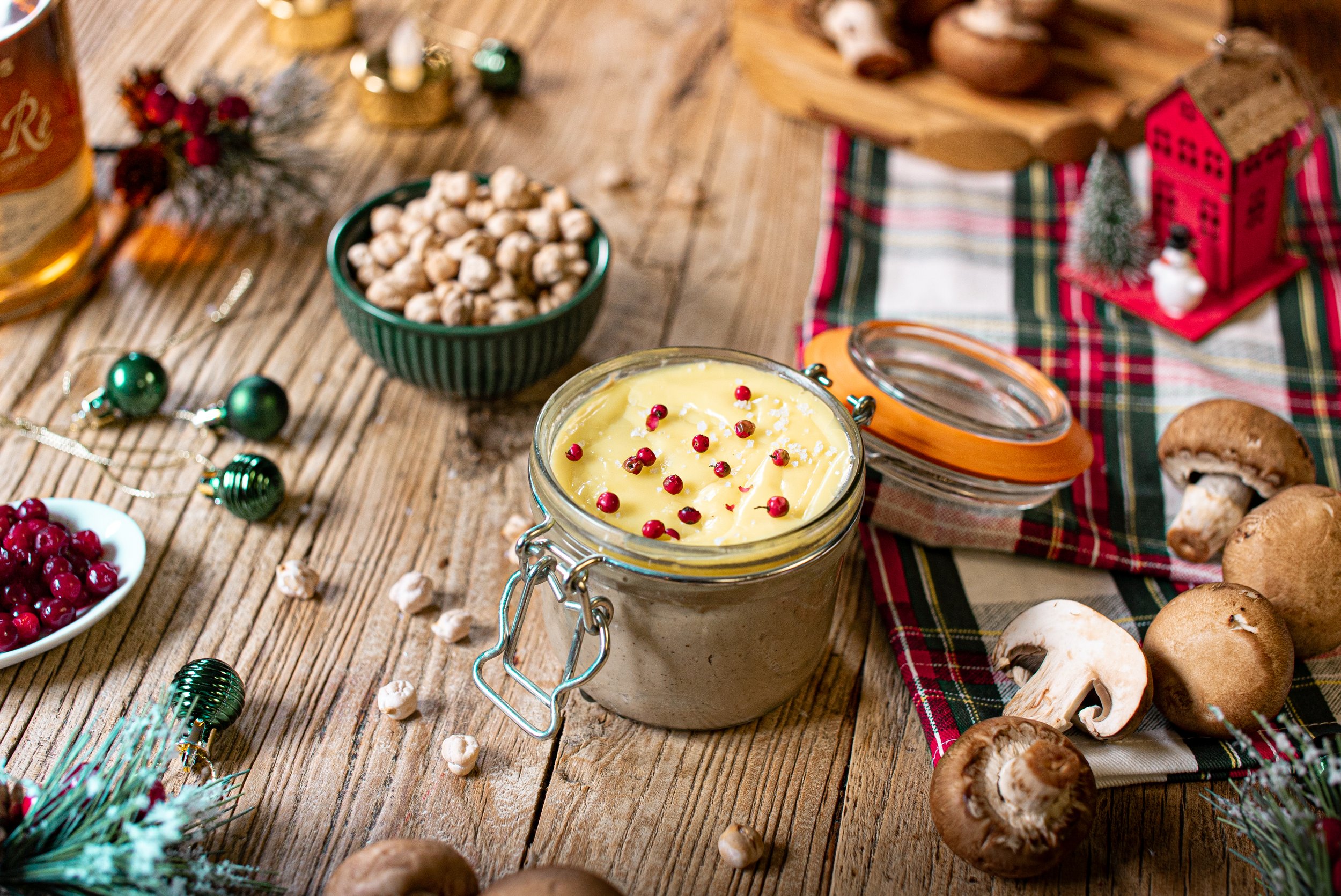 Foie gras 100% végétal : un bocal de délicieux foie gras de champignons maison, mis en valeur au cœur d'une table de Noël décorée pour l'apéritif, évoquant le partage et la gourmandise.