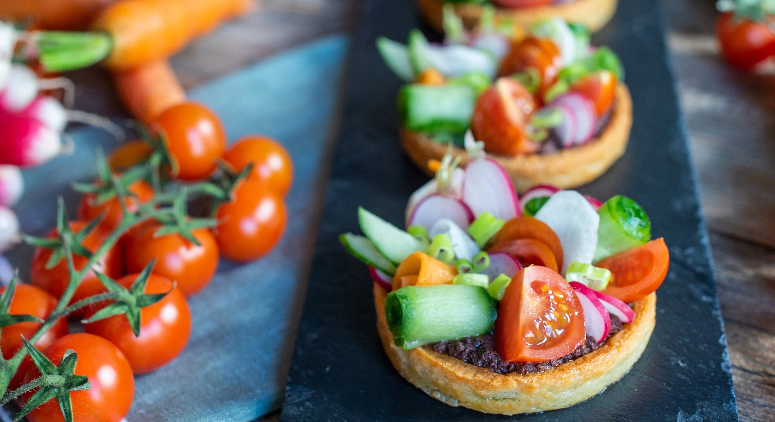 Tartelettes vegan garnies de crudités croquantes et tapenade, présentation estivale