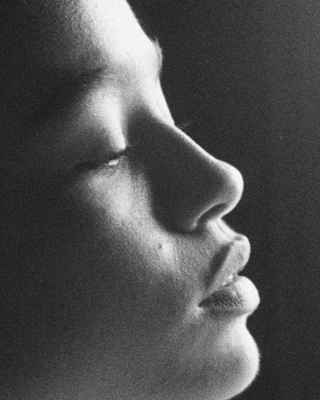 proche d'une femme en profil, yeux fermés, expression calme, en noir et blanc