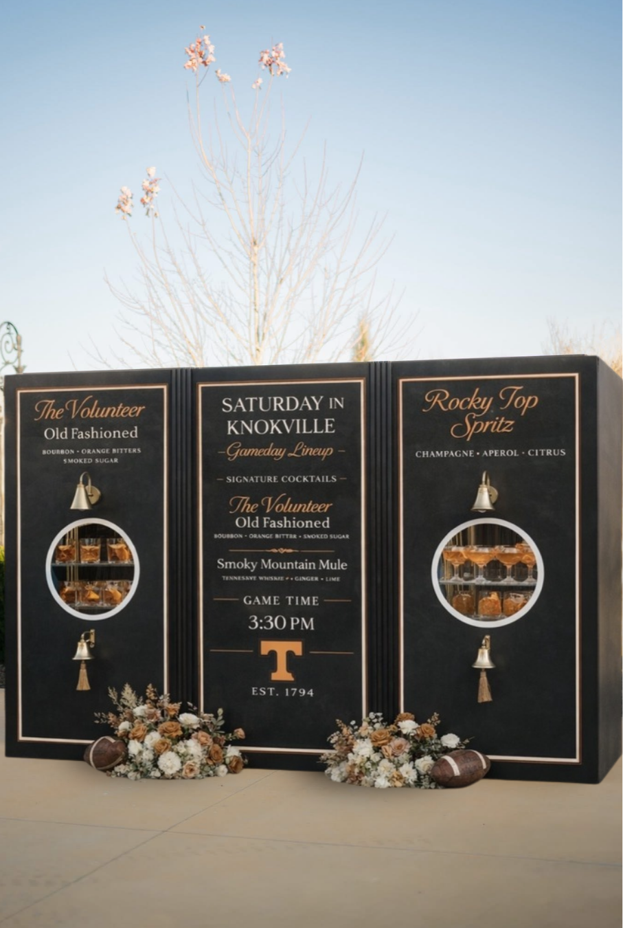 Event promotional board with black background, gold accents, and floral decorations, featuring whiskey, cocktail, and game details for Saturday in Knoxville, with Tennessee Volunteers theme.