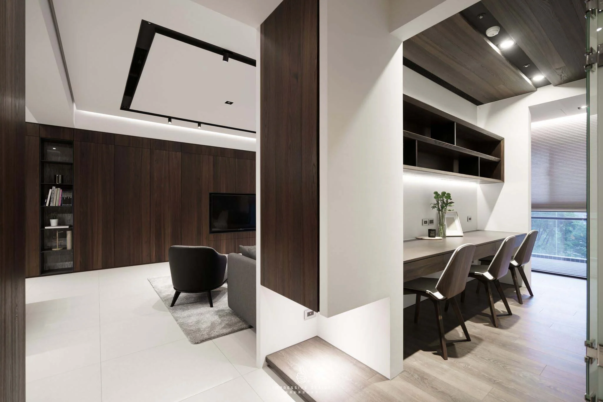 Modern living room and workspace with dark wood paneling and furniture, white walls, and large window with blinds.