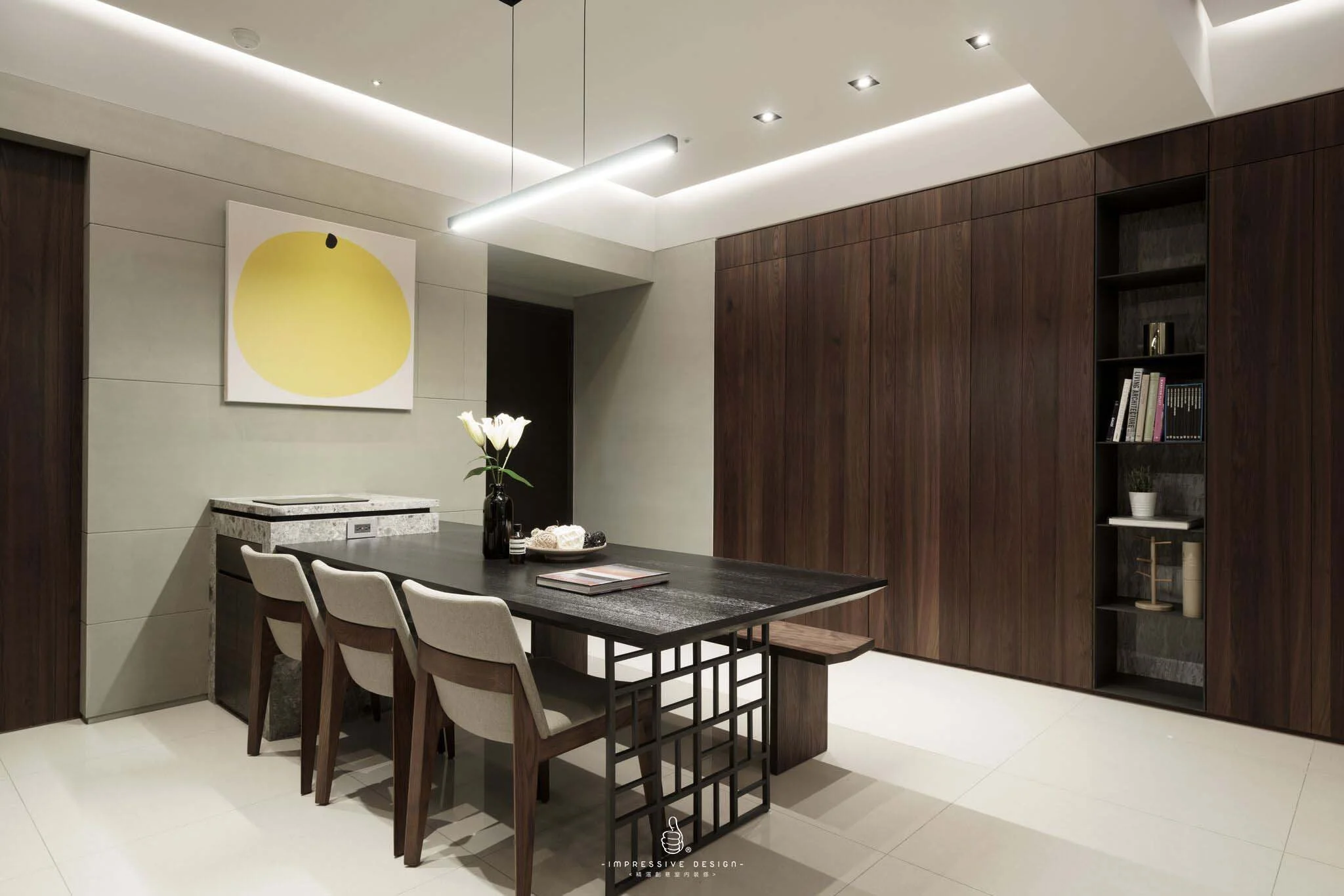 Modern dining room with a black table, four beige chairs, a black vase with white flowers, and built-in wooden wall cabinets.