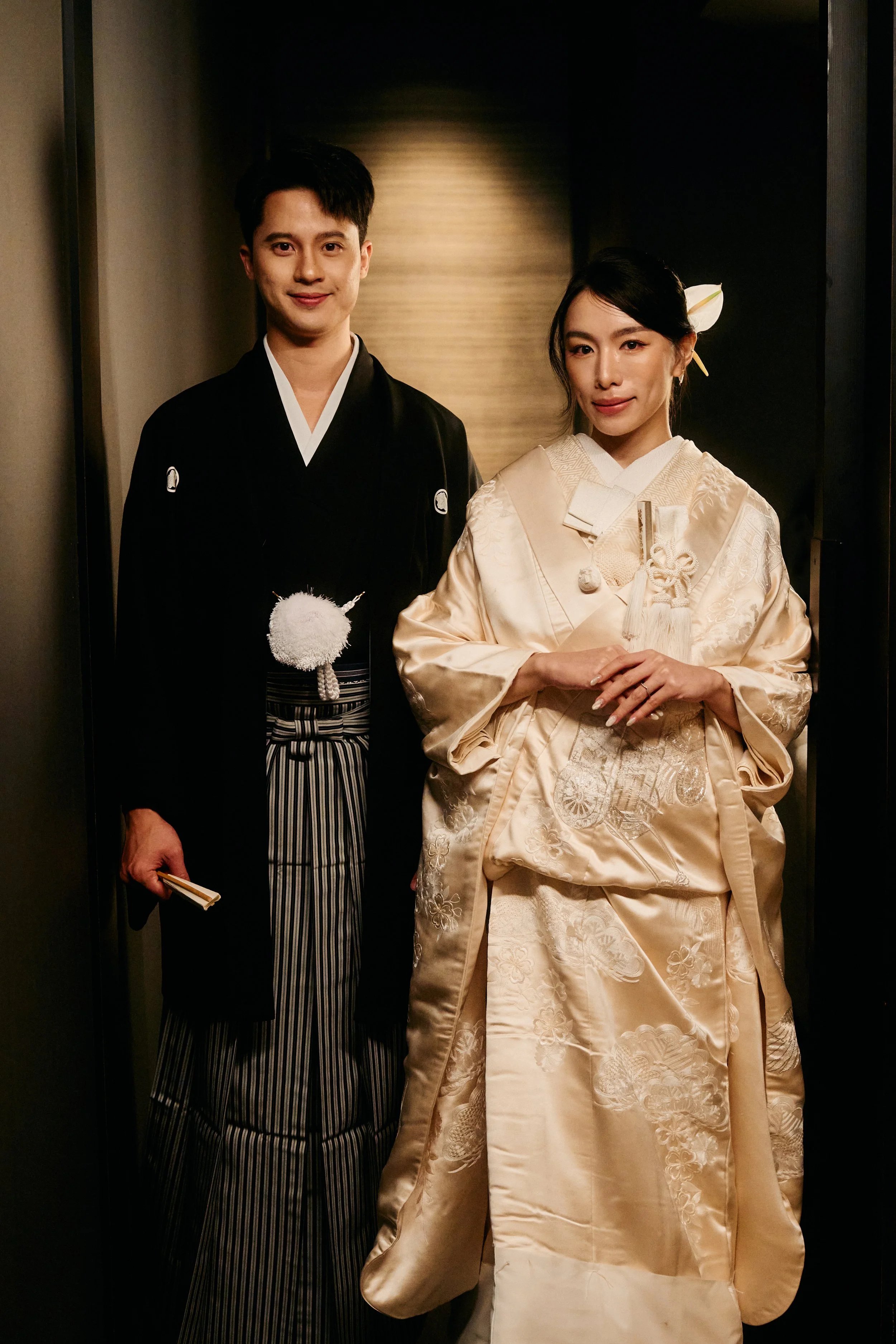 A man and a woman dressed in traditional Japanese wedding attire standing in an elevator.