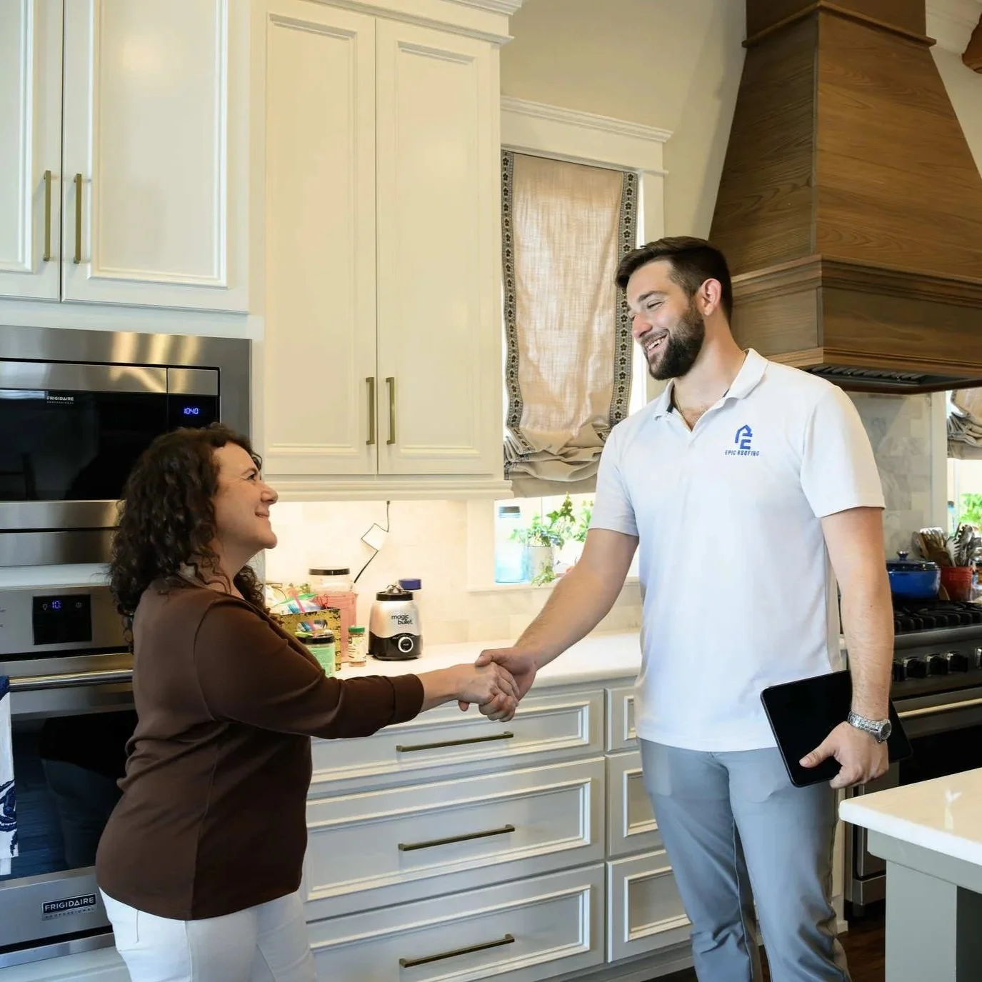 Homeowner shaking hands with roofing professional during hurricane roof preparation consultation and residential storm-readiness inspection appointment indoors.