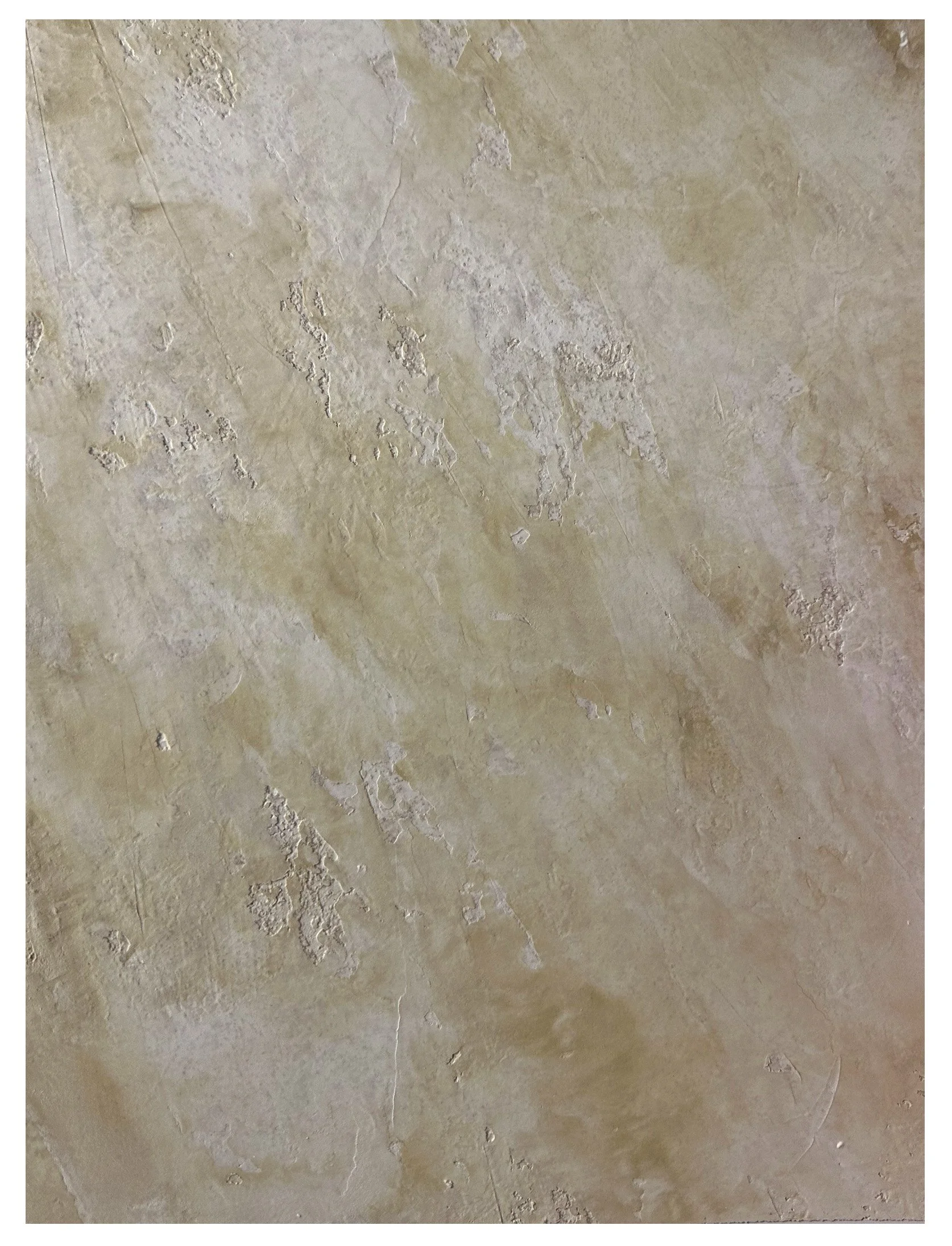 Close-up of a textured beige and tan stone or plaster wall surface with irregular patterns and subtle color variations.