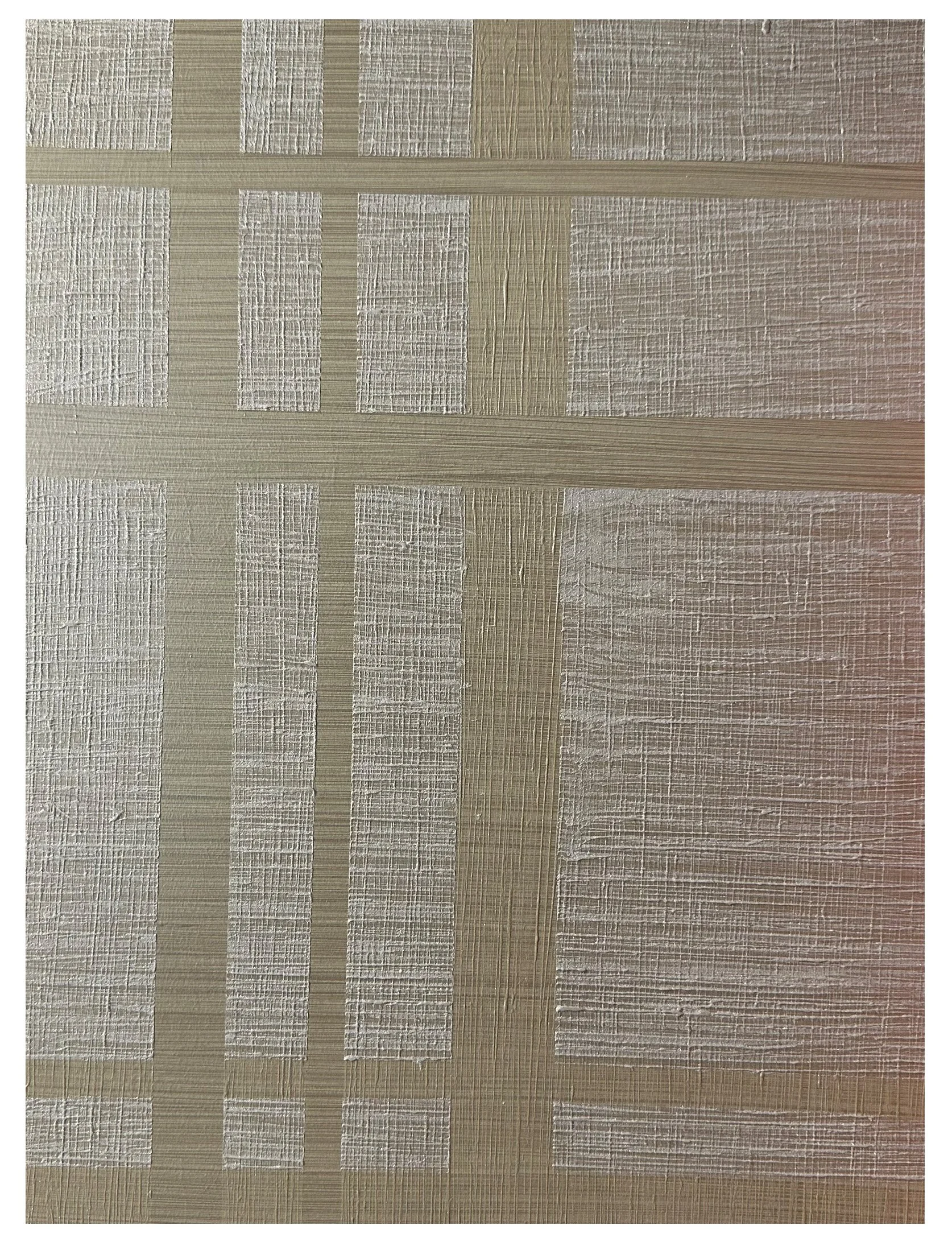 Close-up of a textured surface with woven or grid patterns in shades of beige and cream.