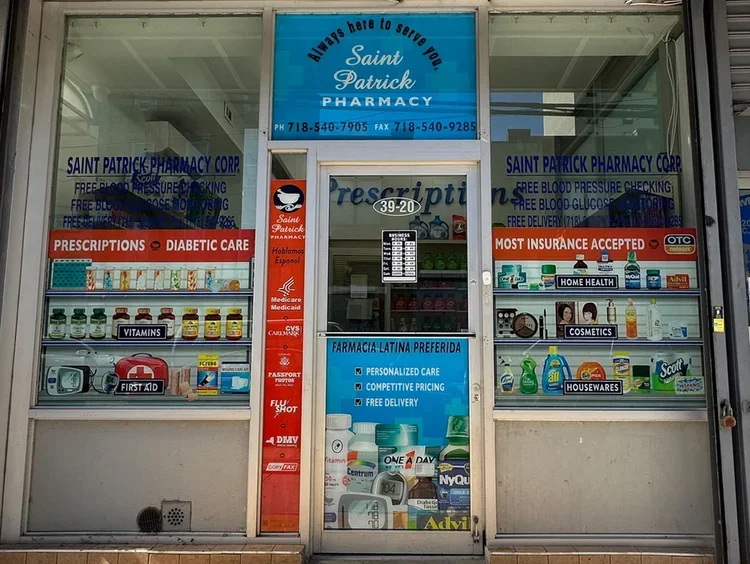 Front of a pharmacy with signs for prescriptions, diabetic care, vitamins, first aid, insurance, home health, cosmetics, housewares, and promotion of personalized care, competitive pricing, and free delivery.