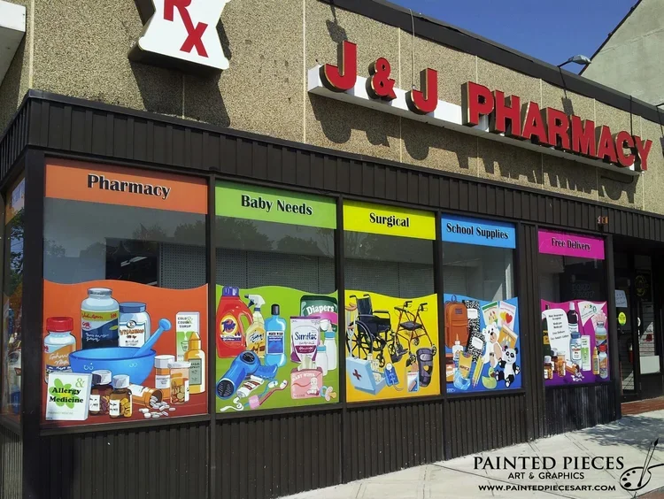 Colorful store window display at J&J Pharmacy, featuring sections for pharmacy, baby needs, surgical supplies, school supplies, and free delivery, with illustrations of medications, baby products, wheelchairs, and school supplies.