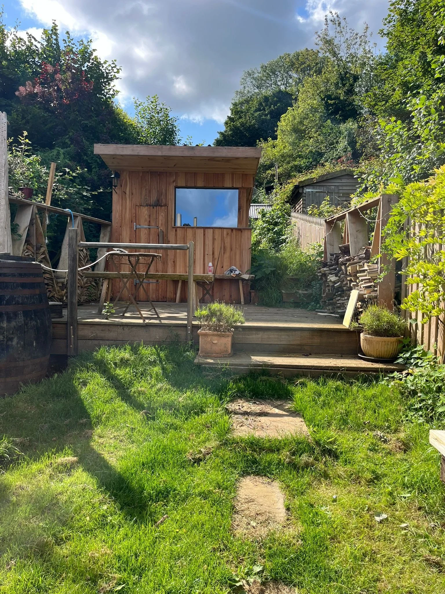 Timber sauna in grassy garden.