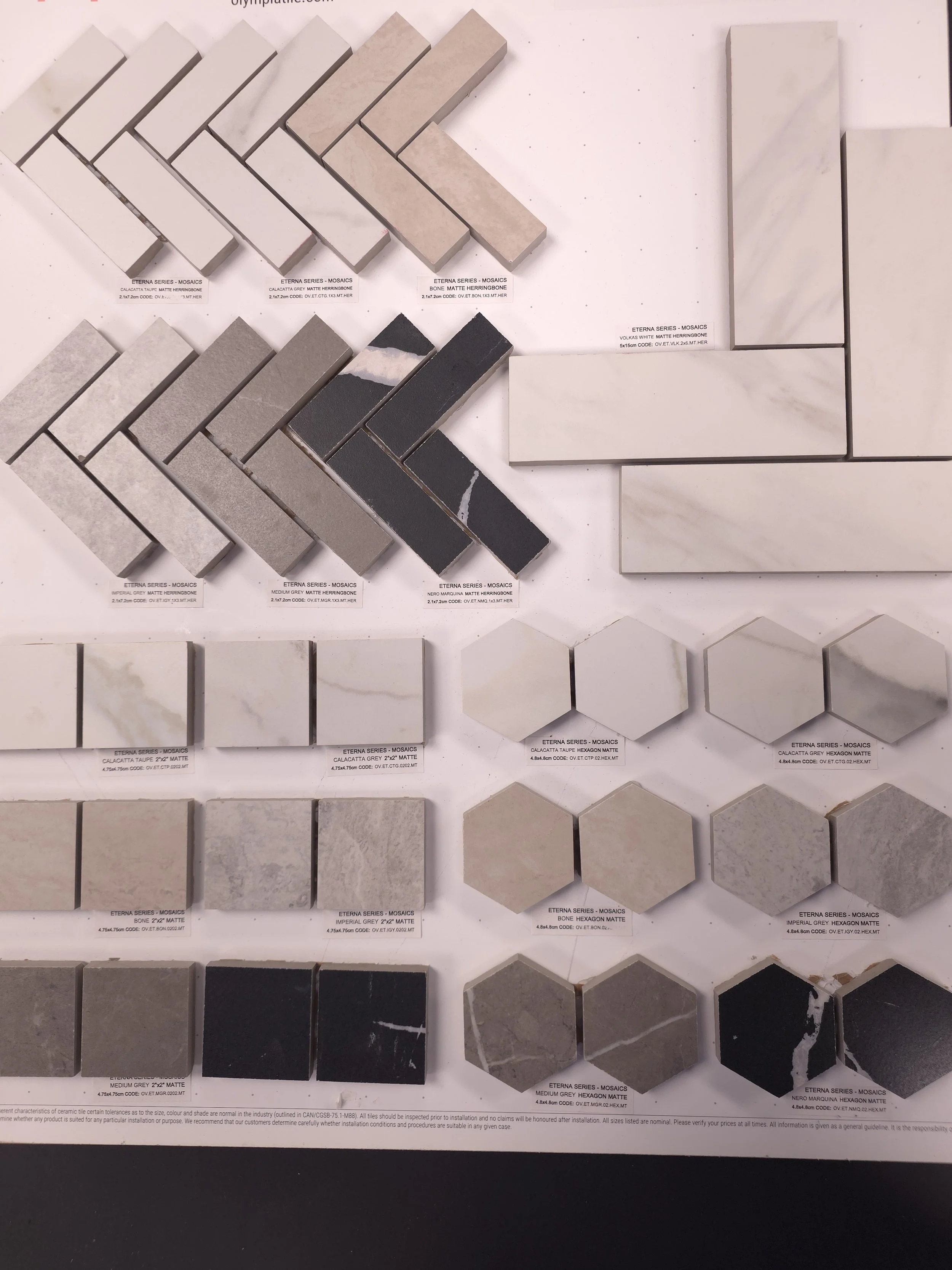 Arrangement of metal mosaic tiles in silver, copper, and black colors on a grid background.