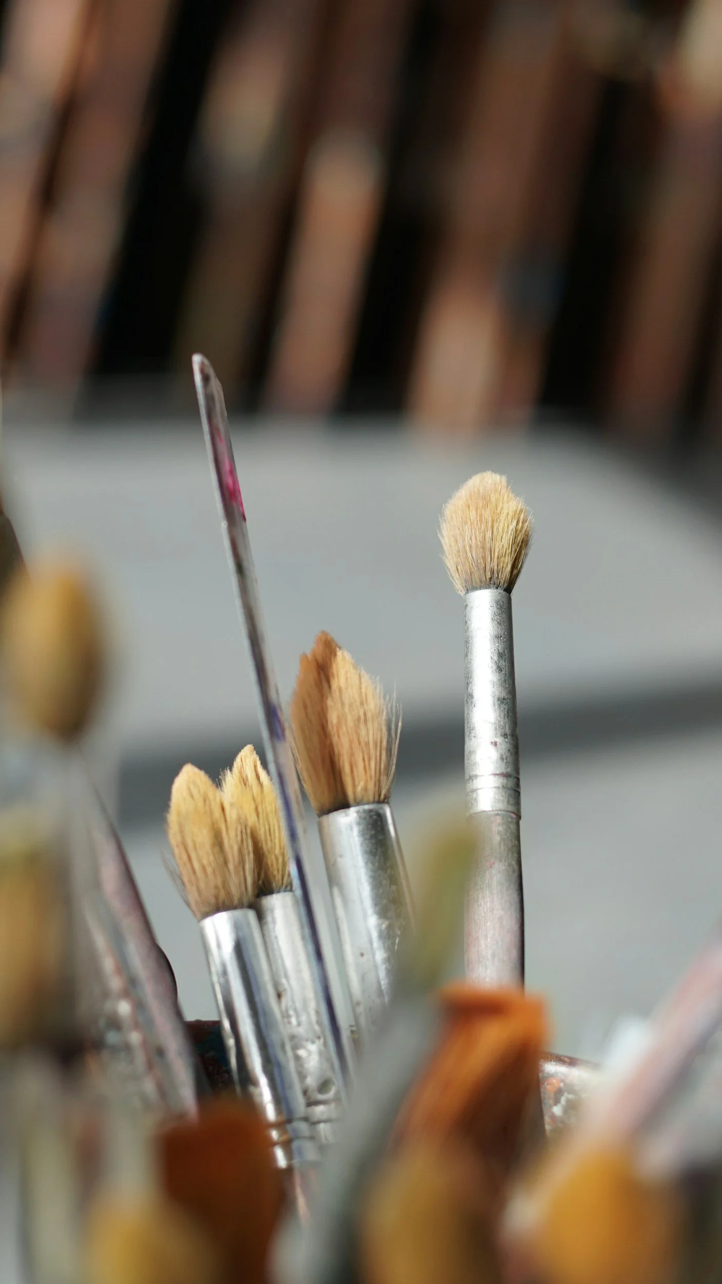 Close-up of various paintbrushes with different shapes and bristle types, stored together.