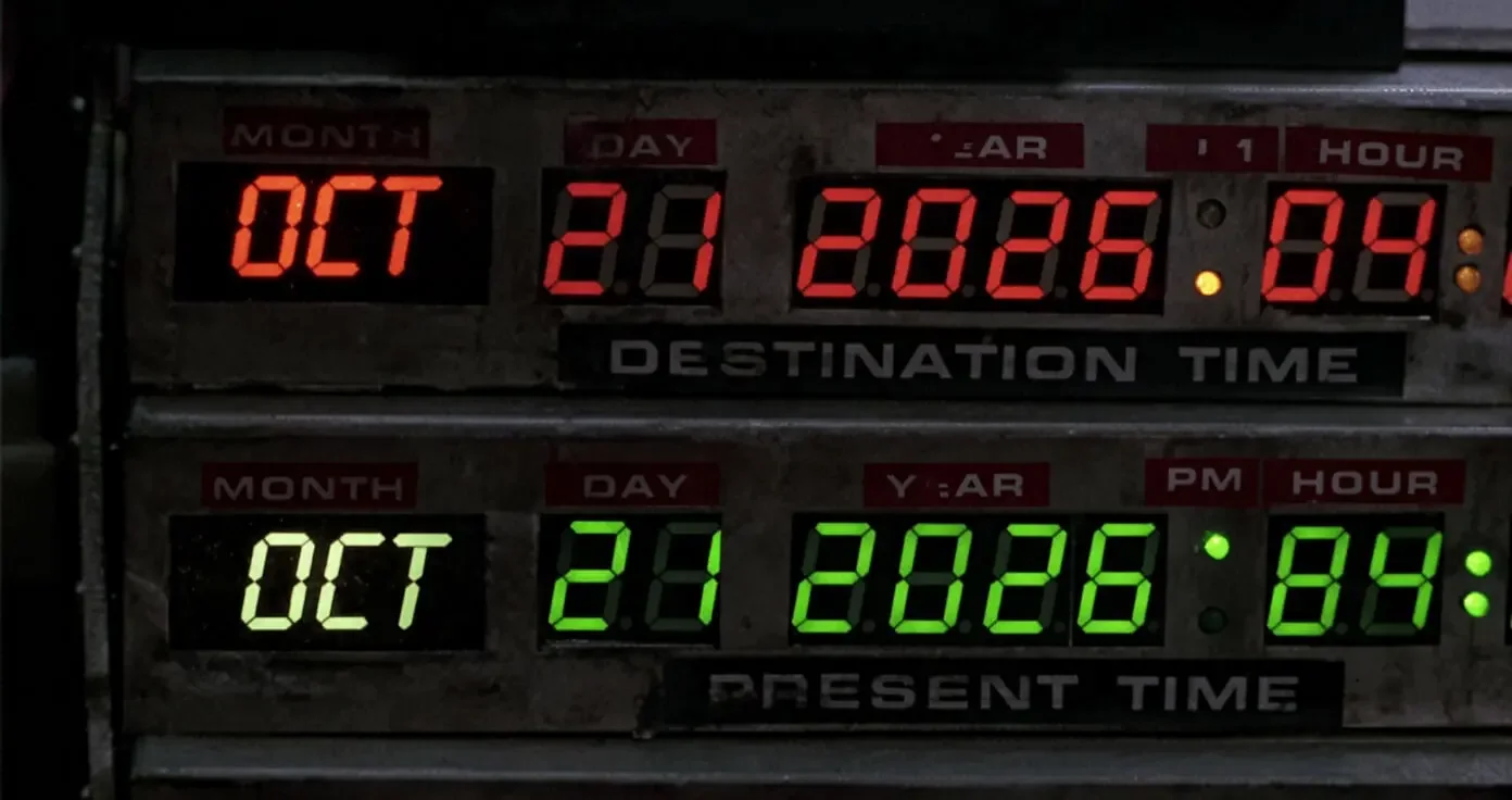 Close-up of the DeLorean time circuit from Back to the Future. The top red LED display (DESTINATION TIME) reads OCT 21 2026 followed by the hour.