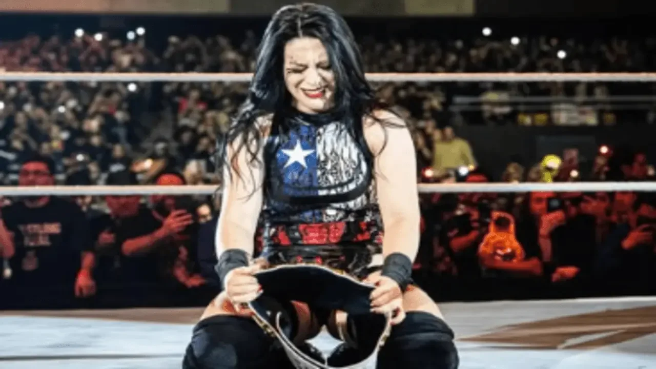 Stephanie Vaquer kneeling in the ring holding the WWE Women's World Championship in front of the crowd in Santiago, Chile.