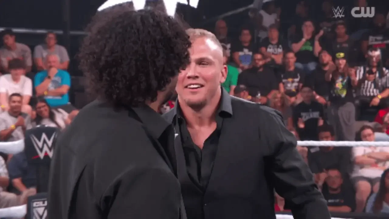 Myles Borne smiles during a tense in-ring hug with Tavion Heights on WWE NXT
