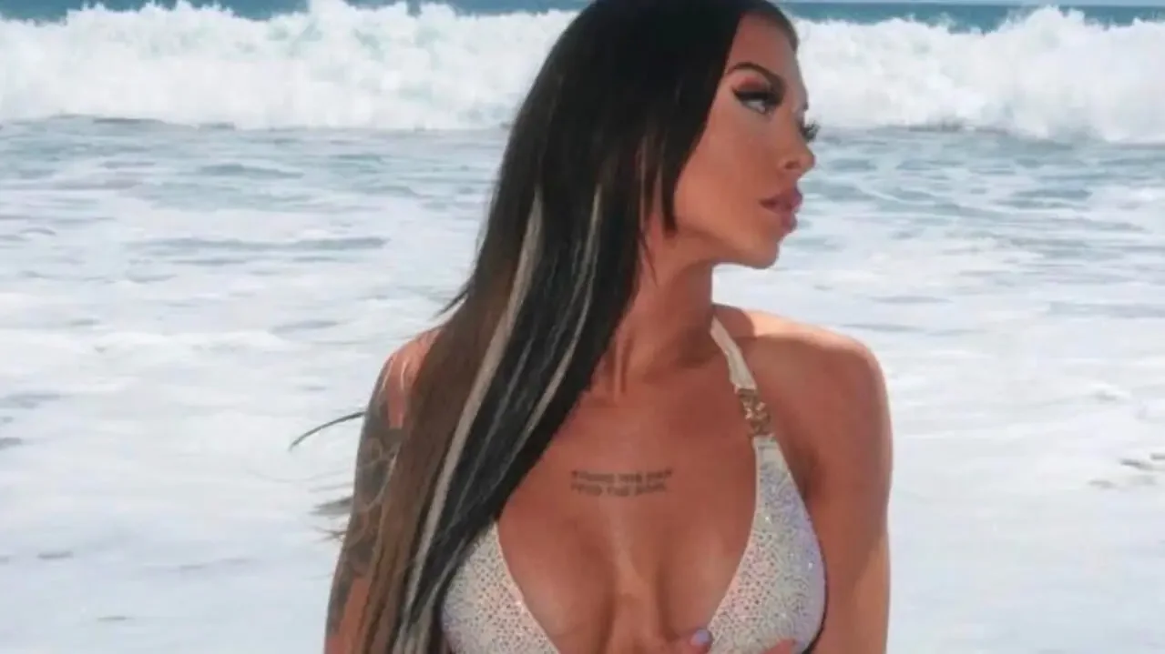 Elayna Black wearing a sparkly white bikini at the beach with ocean waves in the background.