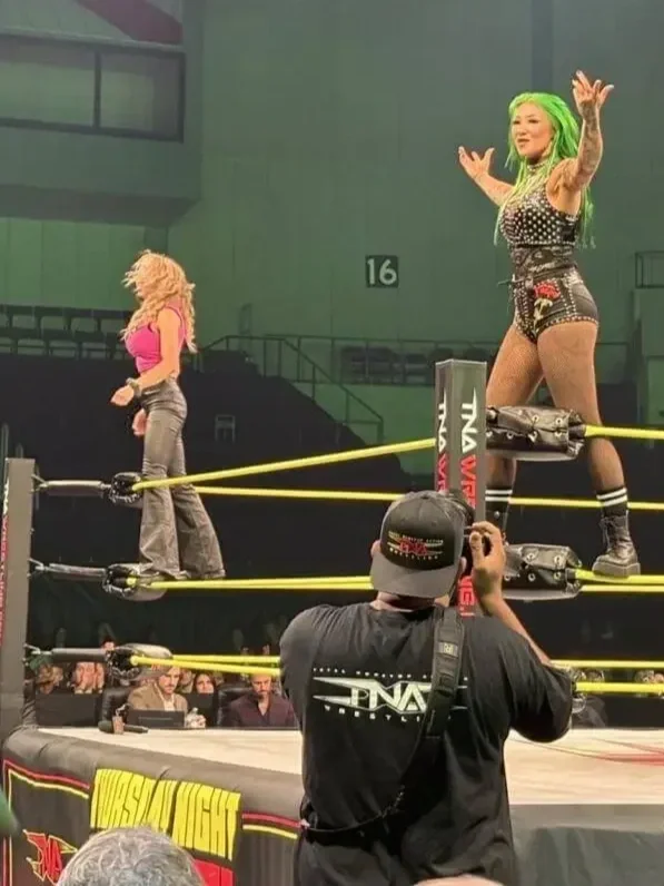 Professional wrestlers Allie and Shotzi pose on the ring ropes during a TNA Wrestling event.