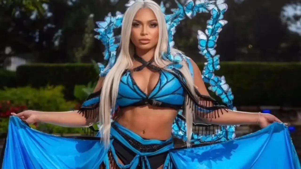 Karissa Rivera posing in a blue butterfly-themed costume with matching wings, long white hair, and outstretched flowing fabric.