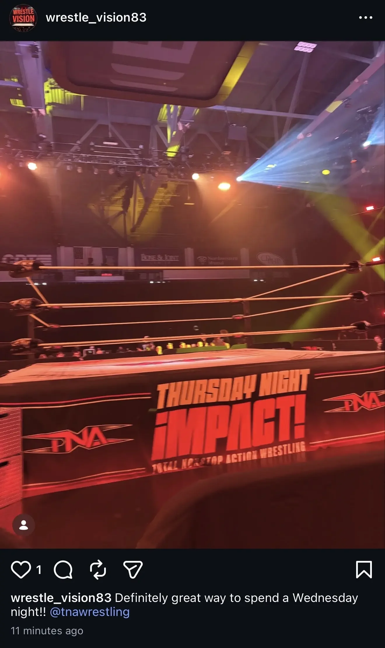 TNA Thursday Night Impact ring setup at Broadview Center in Albany with dramatic blue and yellow lighting beams over a sparsely filled arena during the July 2026 taping.