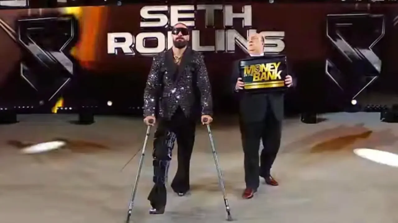 Seth Rollins on crutches with a knee brace and sunglasses, walking down the ramp with Paul Heyman carrying the Money in the Bank briefcase.