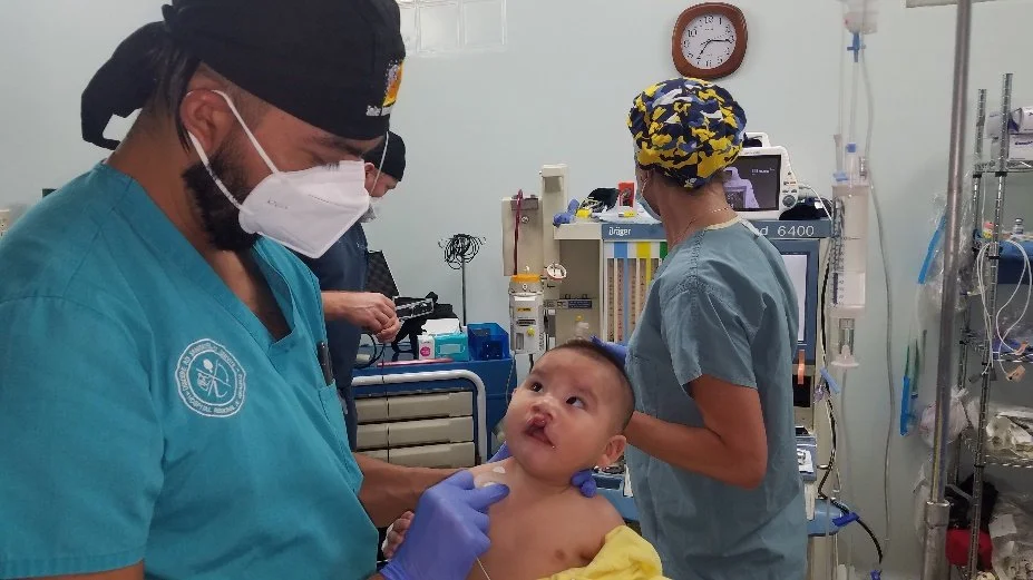 A young child receiving medical care from healthcare professionals in a hospital setting.