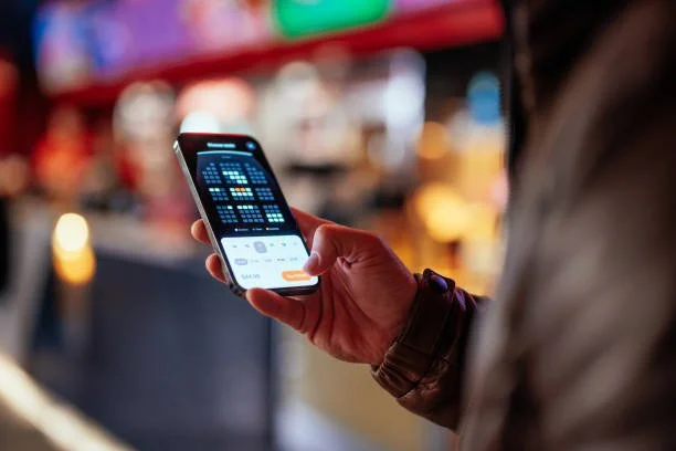 Close-up of a person using a smartphone to book tickets online, illustrating seamless mobile conversions driven by Claddagh Digital's targeted social media advertising campaigns.