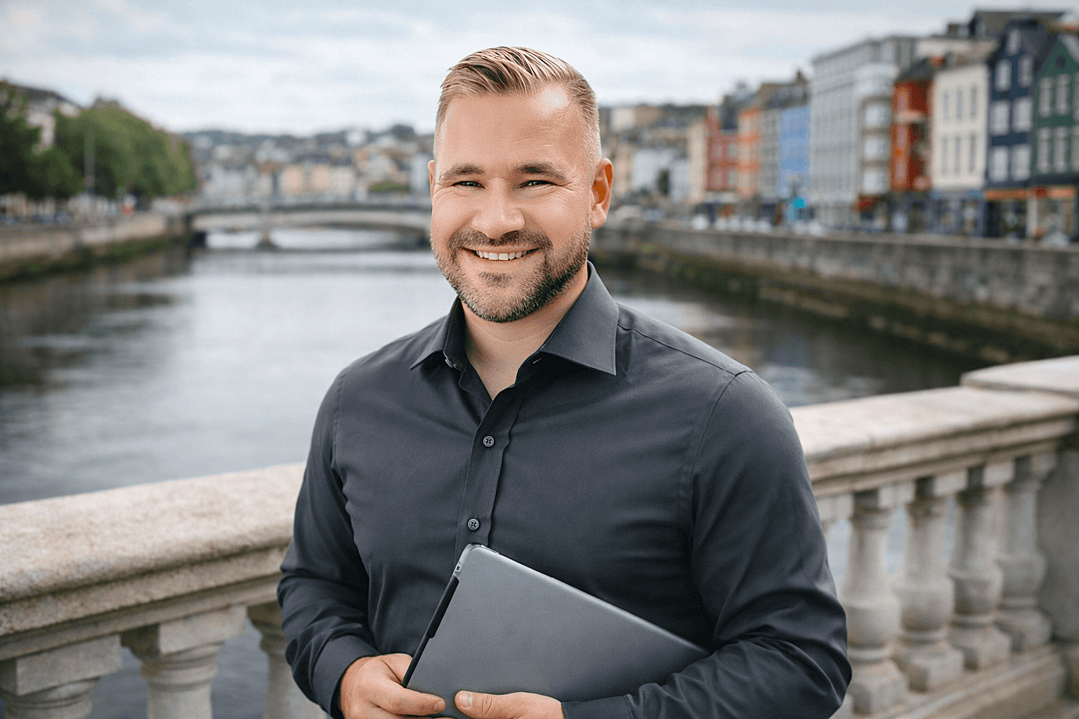Smiling social media consultant standing by the river in Cork City, representing Claddagh Digital – a Cork‑based social media consultancy offering local‑heart, European‑level expertise for Irish businesses.