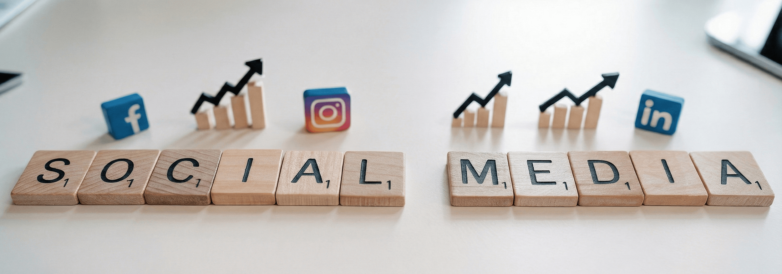 Scrabble letters spelling "SOCIAL MEDIA" on a white desk with Facebook, Instagram, LinkedIn icons and growth charts, representing social media marketing services in Cork.