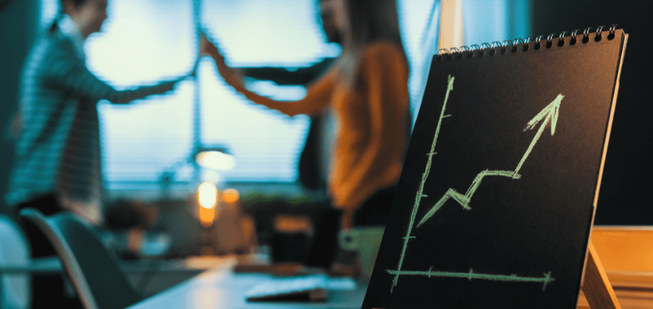 Chalkboard with an upward-trending growth graph, with people high-fiving in the background, representing successful Facebook management and client results in Cork.