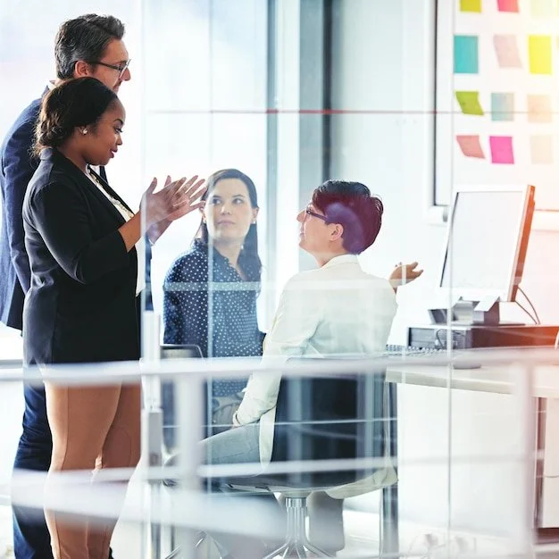 A diverse group of professionals discussing a project while looking at a computer screen in a modern office at Claddagh Digital Cork.