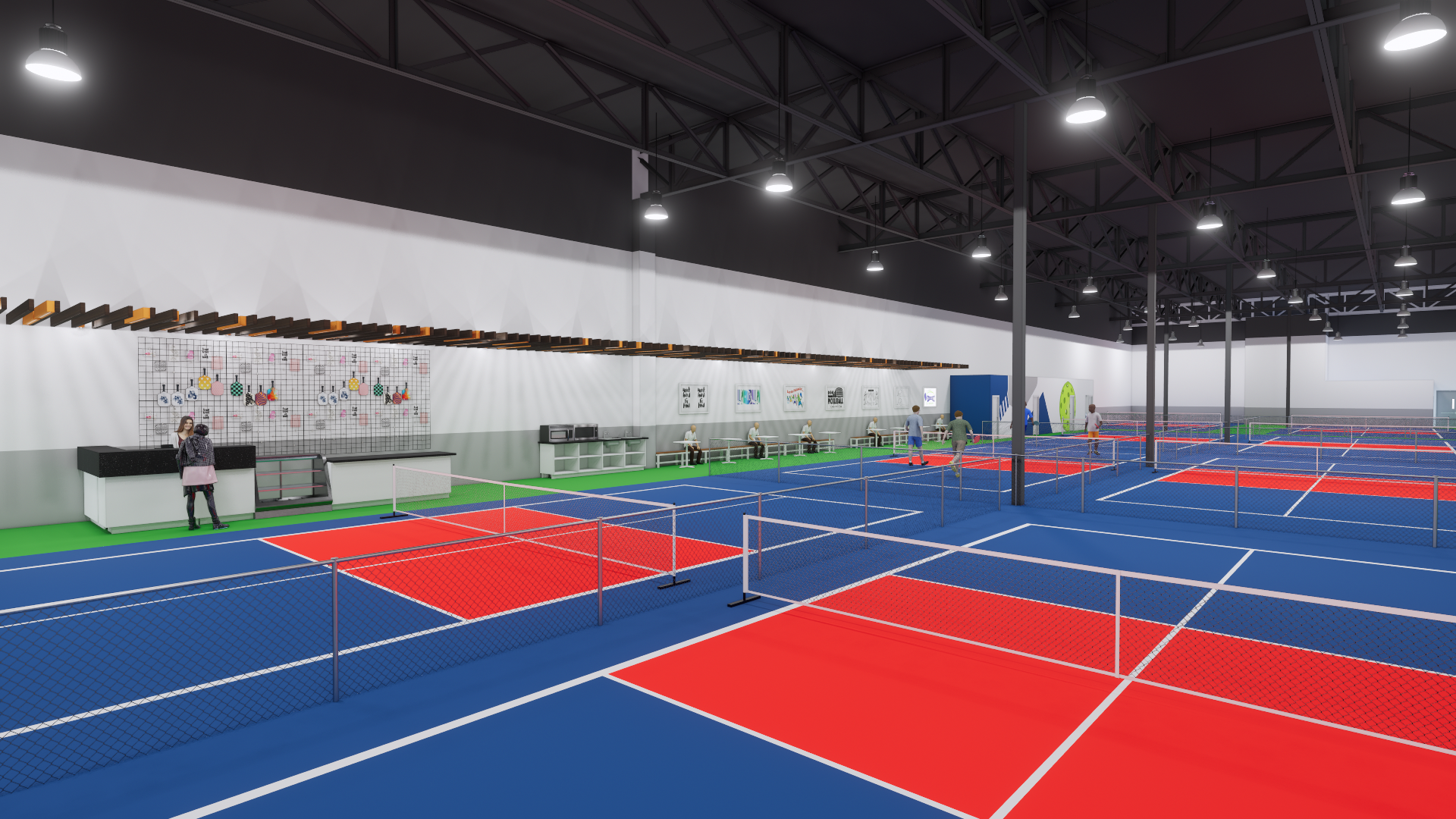 Indoor tennis facility with multiple blue and red tennis courts, chain-link fencing, seating area along the wall, and a high ceiling with industrial lighting.