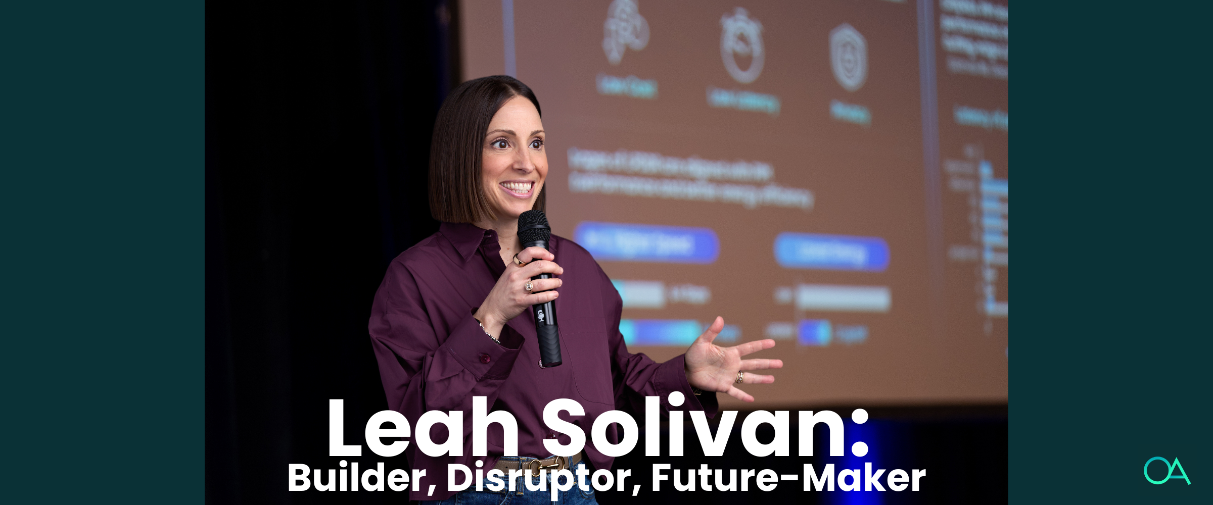 Taskrabbit Founder Leah Solivan with short brown hair and a purple oxford shirt standing on a stage holding a microphone in front of a presentation screen