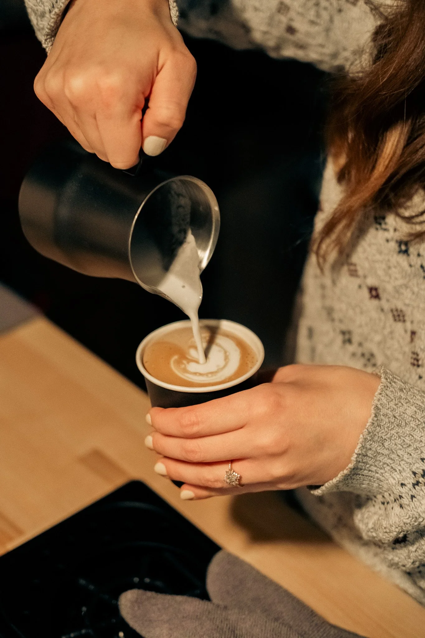 Modern building with wooden exterior, large glass window, and mountain landscape in the background.