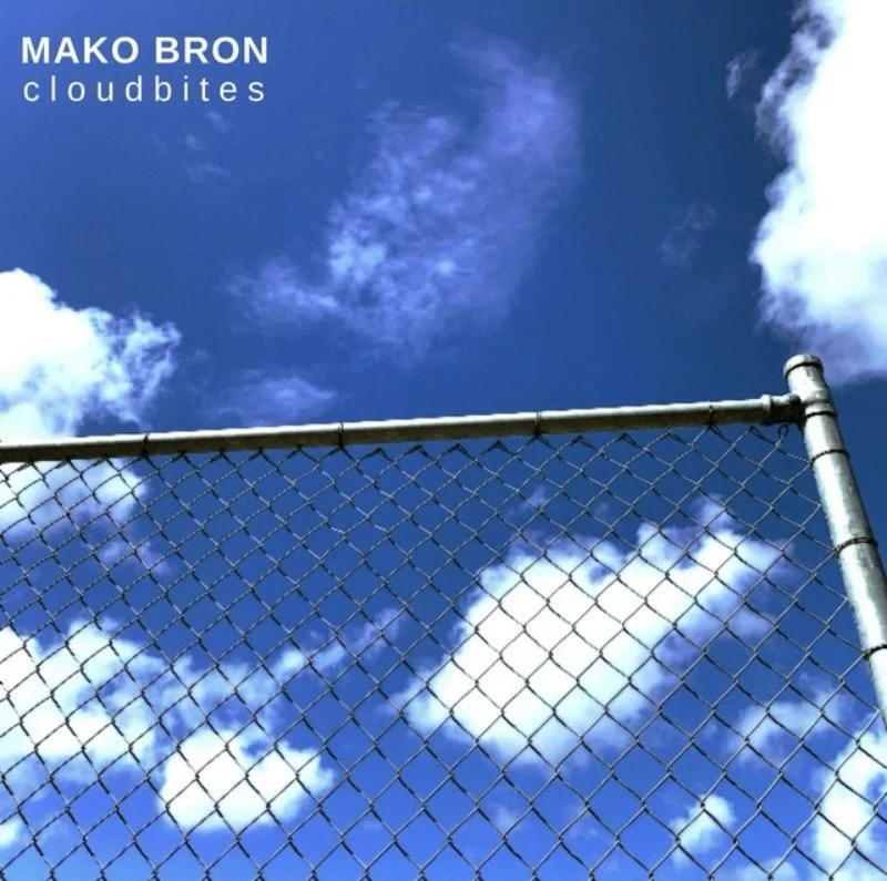 A chain-link fence against a bright blue sky with scattered white clouds.